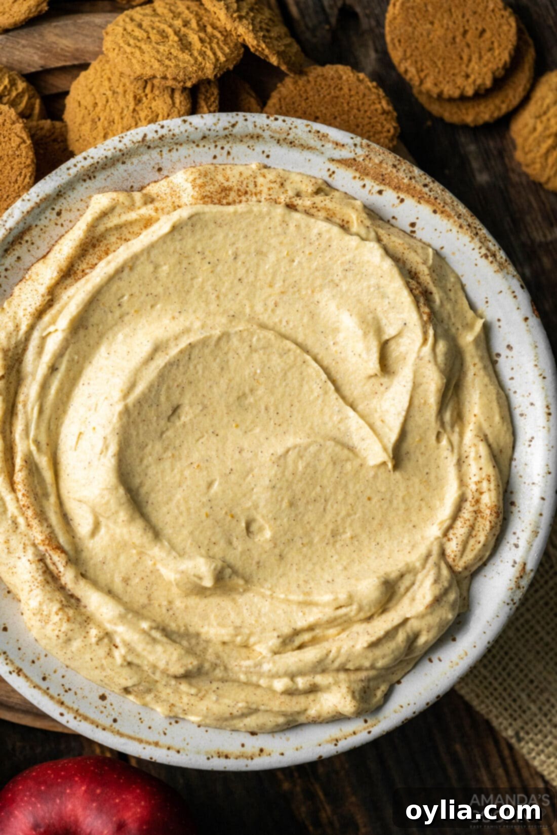 Overhead shot of a beautifully presented bowl of Pumpkin Pie Dip surrounded by a variety of dipping options for a festive fall display.