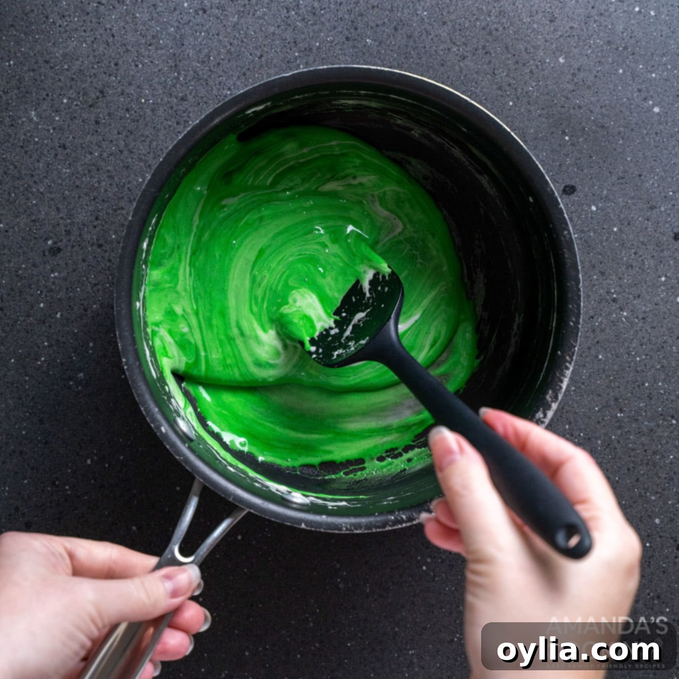 Monster Mash Krispie Treats 7 spoon stirring green food coloring into melted marshmallows