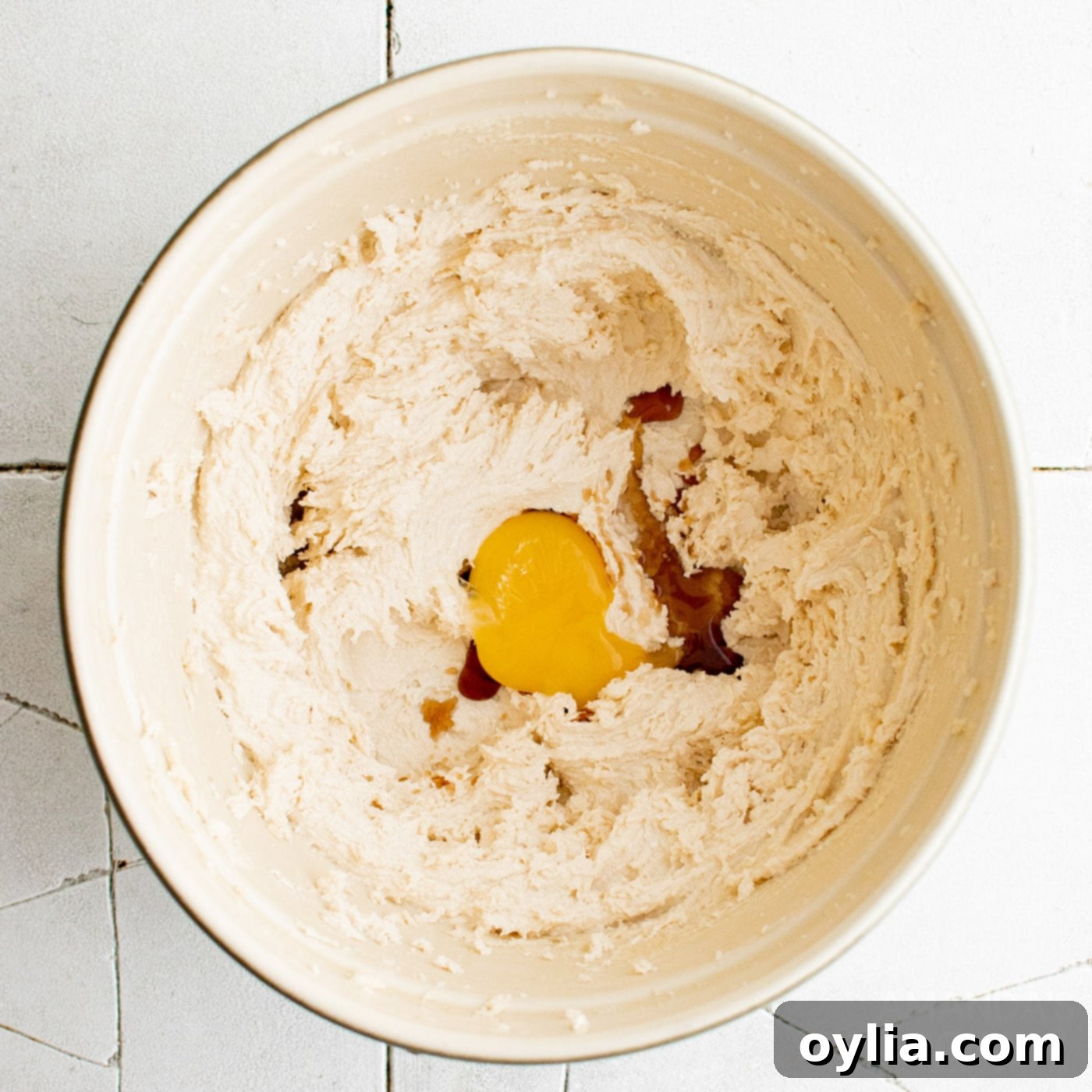 egg yolk in mixing bowl with butter and sugar mixture