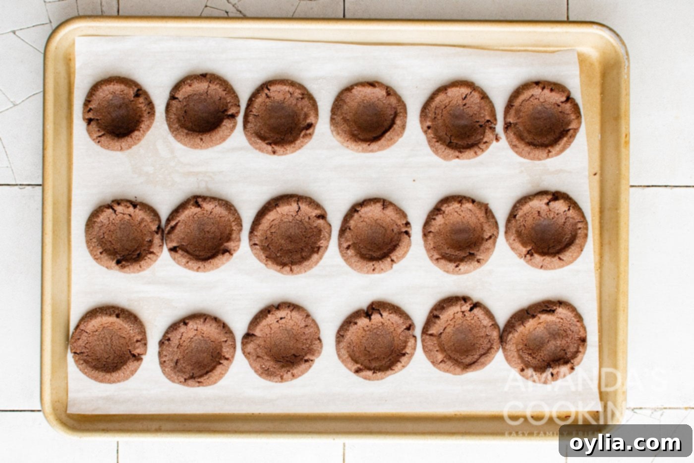 baked chocolate thumbprint cookies on cookie sheet