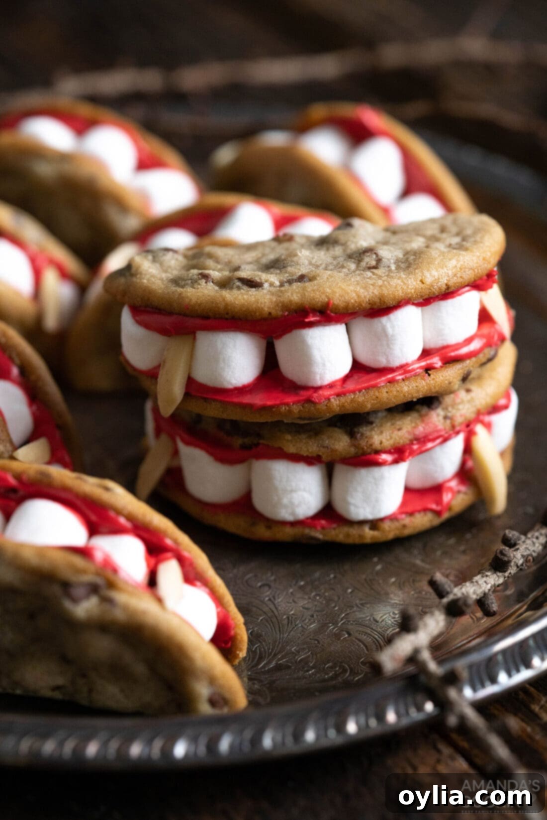 Vampire's Kiss Sandwich Cookies 2 Vampire Sandwich Cookies on a plate, showcasing the fangs and bloody frosting