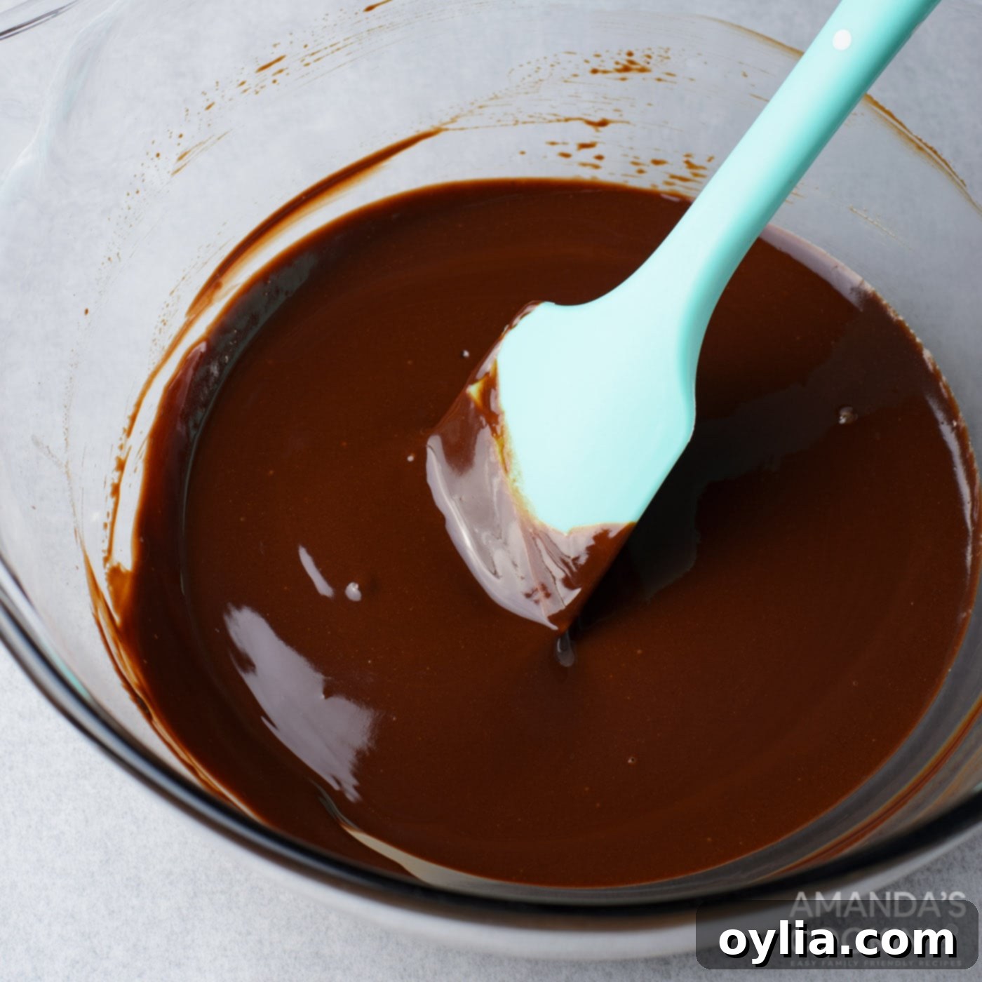 melted chocolate in a bowl with a rubber spatula