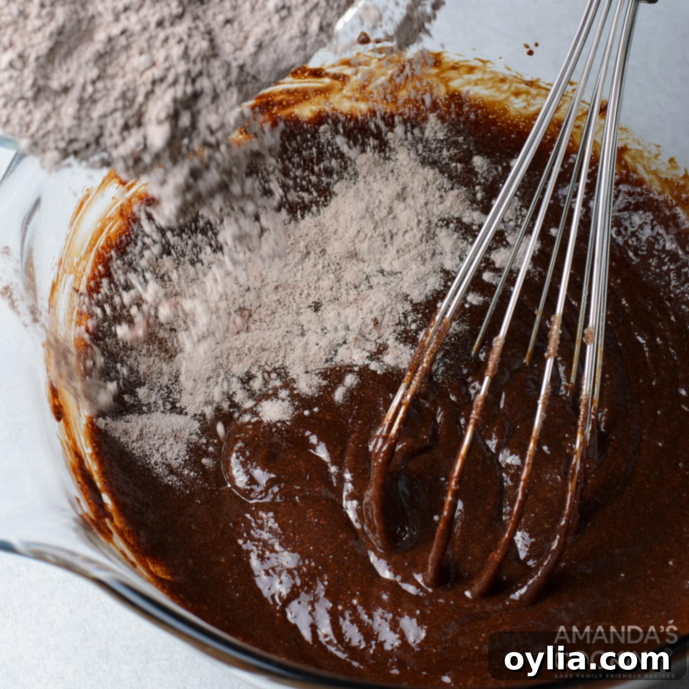 dry ingredients added to brownie batter with a whisk