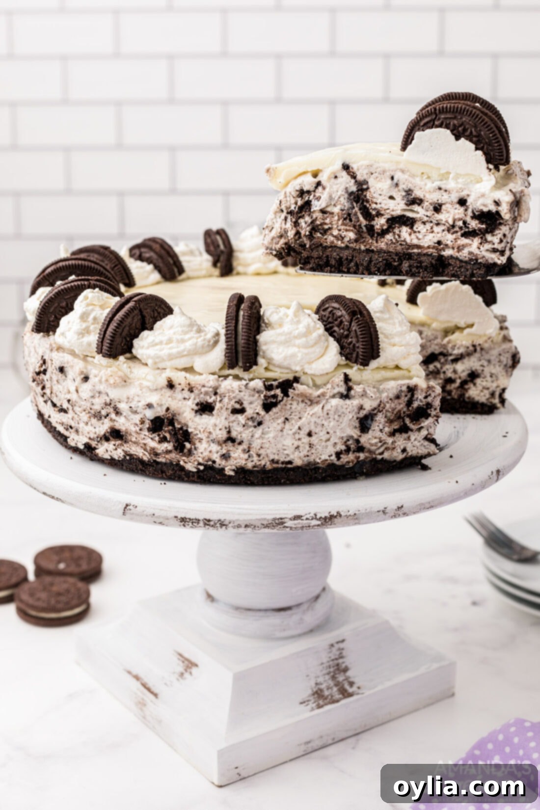 A slice of Oreo cheesecake being carefully removed from the main cake, ready to be served.