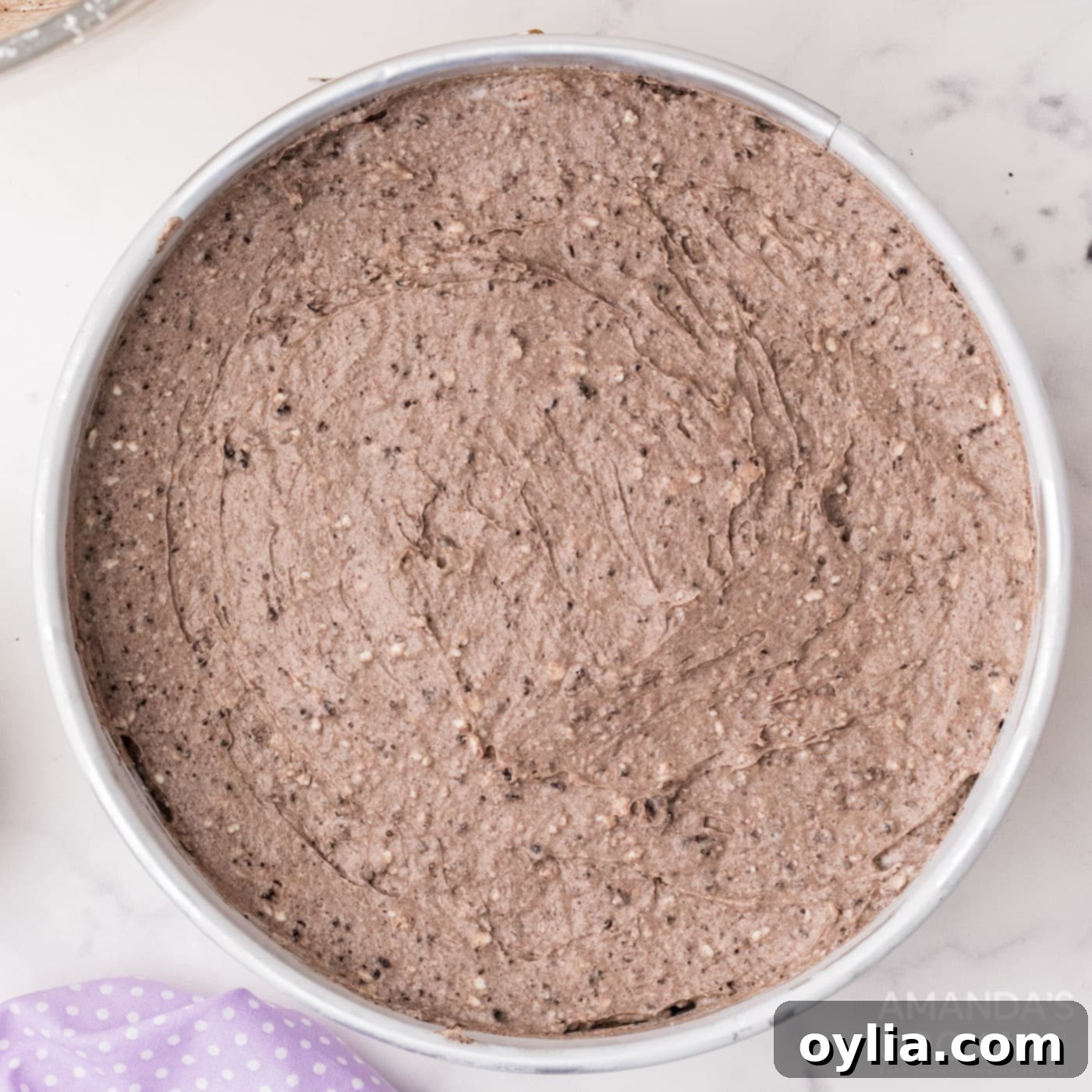 Oreo cheesecake filling poured into the springform pan over the cooled crust.
