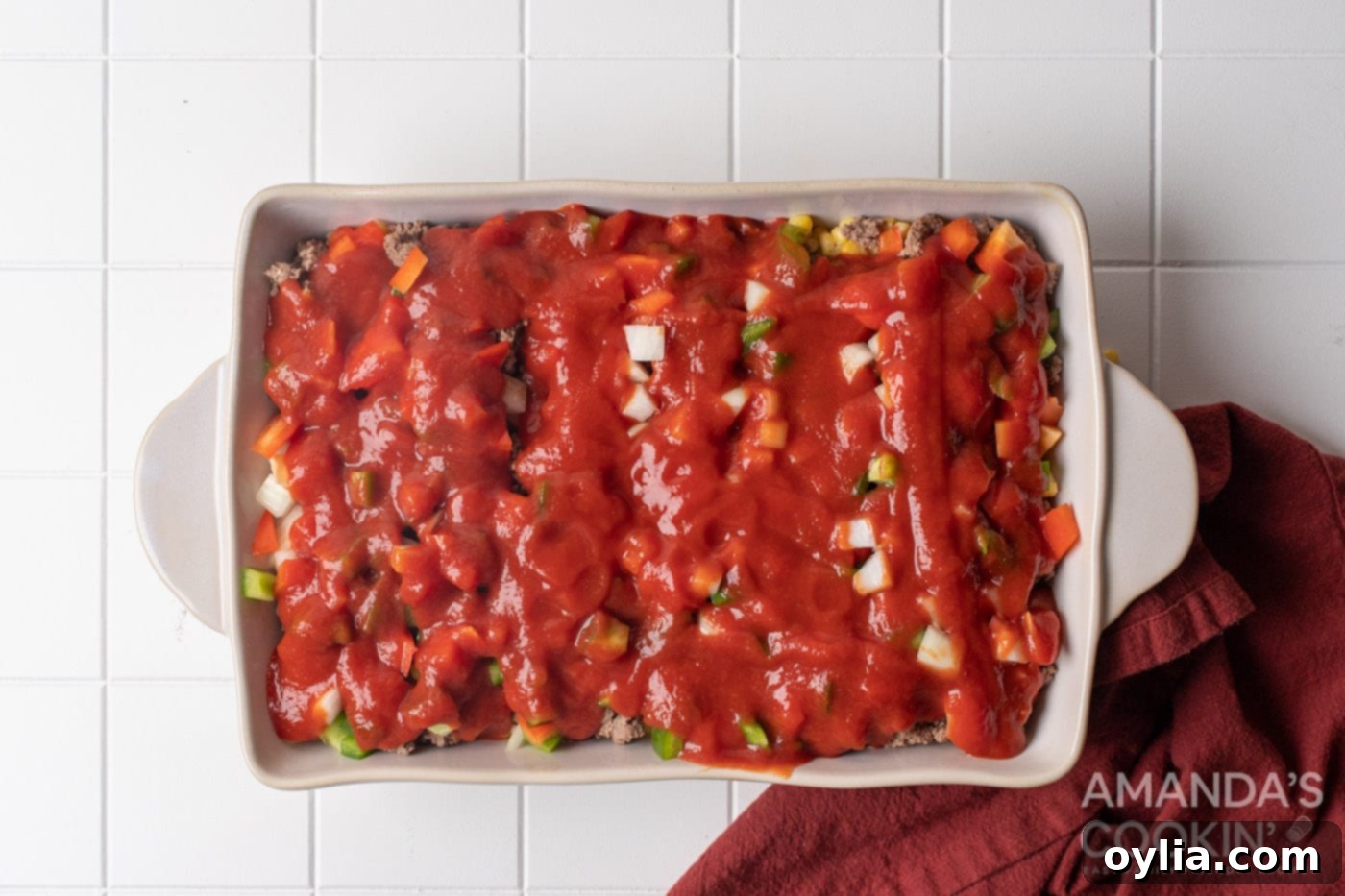 Stacked Supper Supreme 9 pasta sauce over veggies in a baking dish