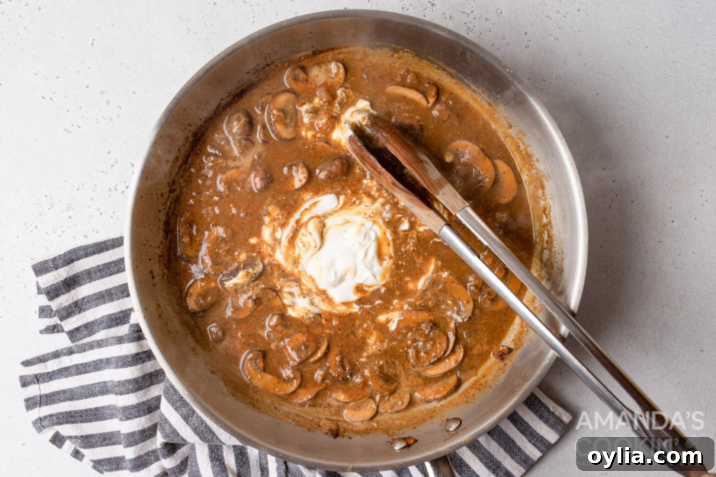stirring sour cream into stroganoff sauce