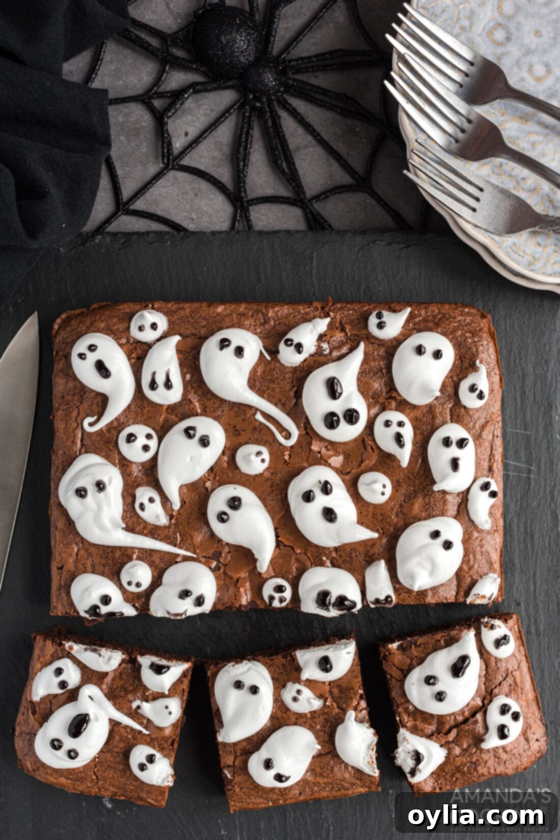 cut pieces of Ghost Brownies, showing individual brownies with piped marshmallow ghosts, ready to be served.