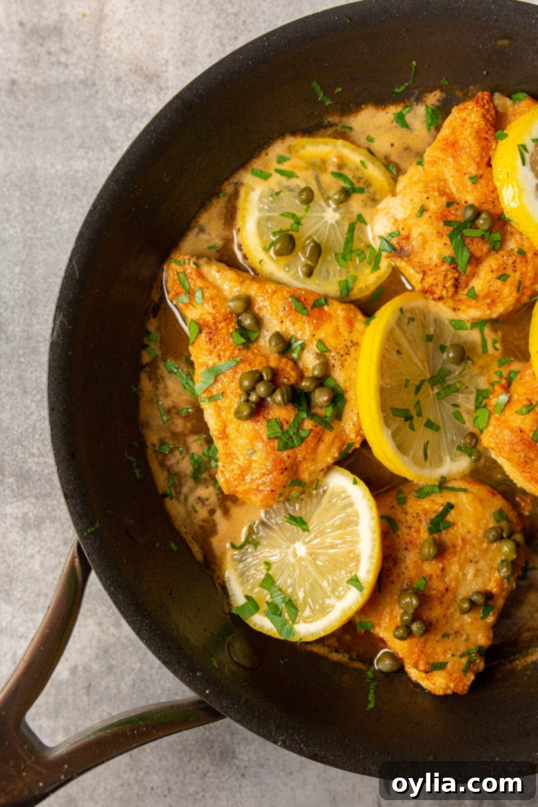 pan of golden brown Chicken Piccata with vibrant lemon-caper sauce