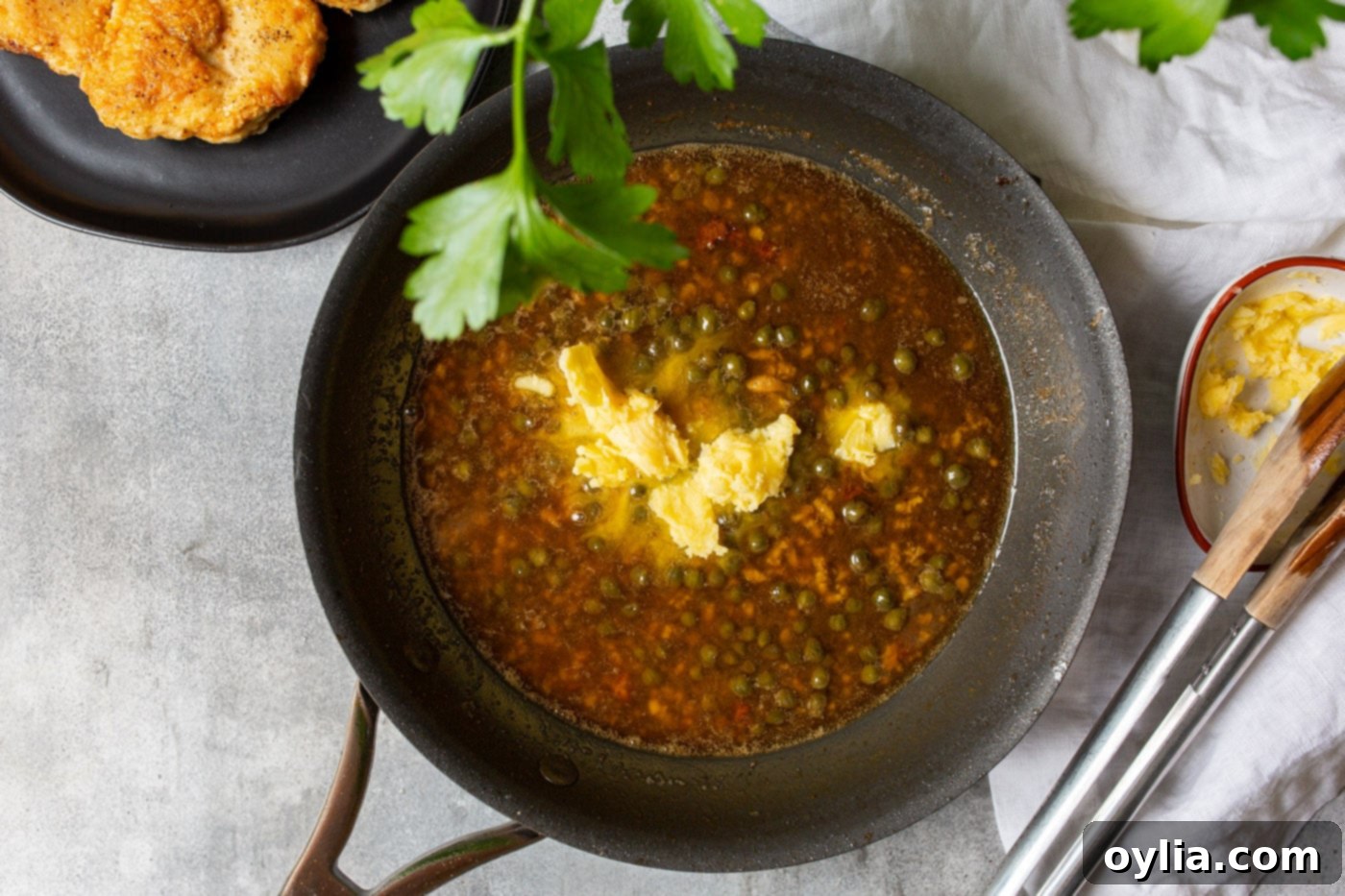 caper, lemon juice, and garlic simmering in a skillet to form the piccata sauce