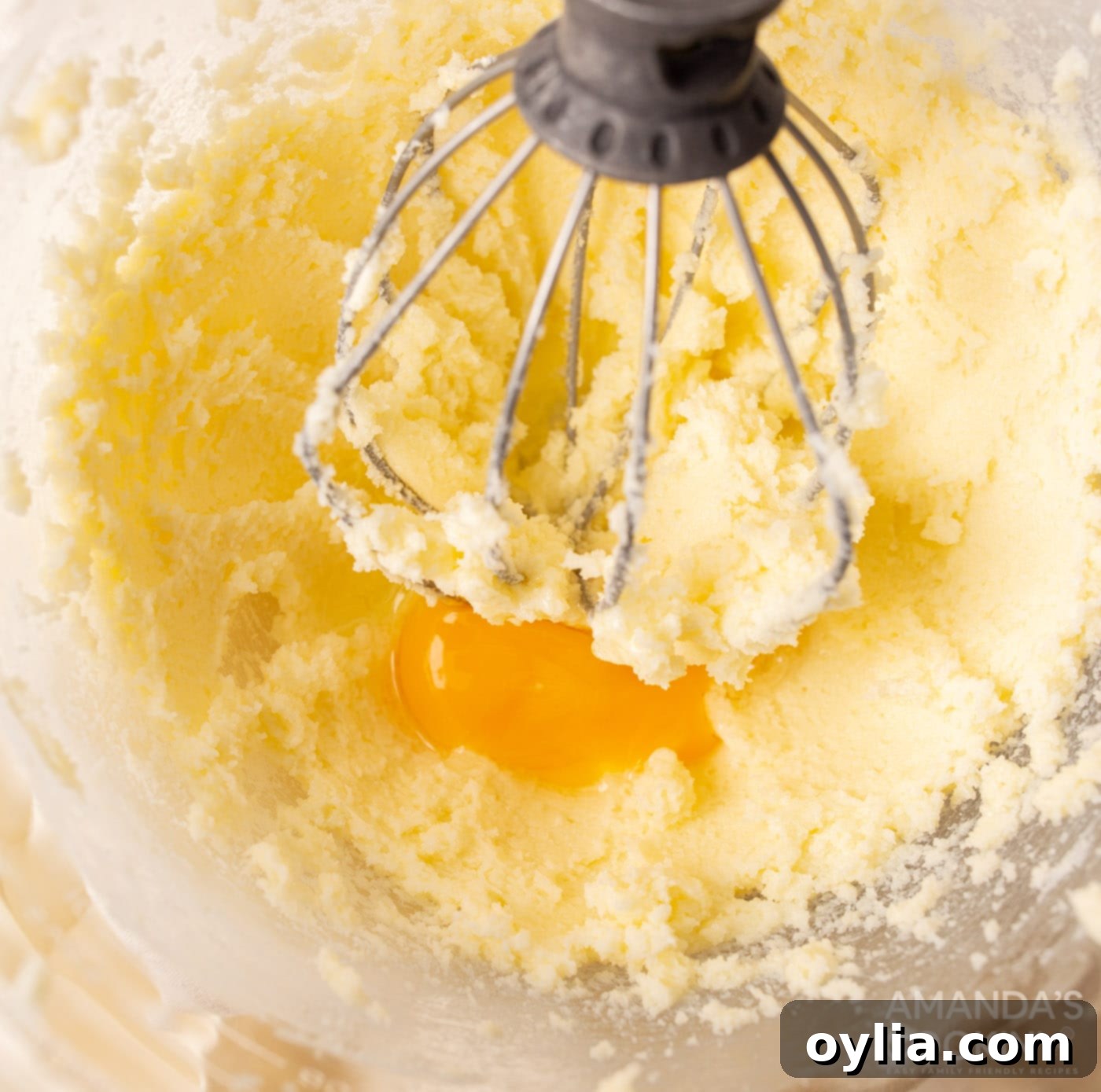 Creamed butter, sugar, egg, and almond extract in a stand mixer bowl, ready for dry ingredients.