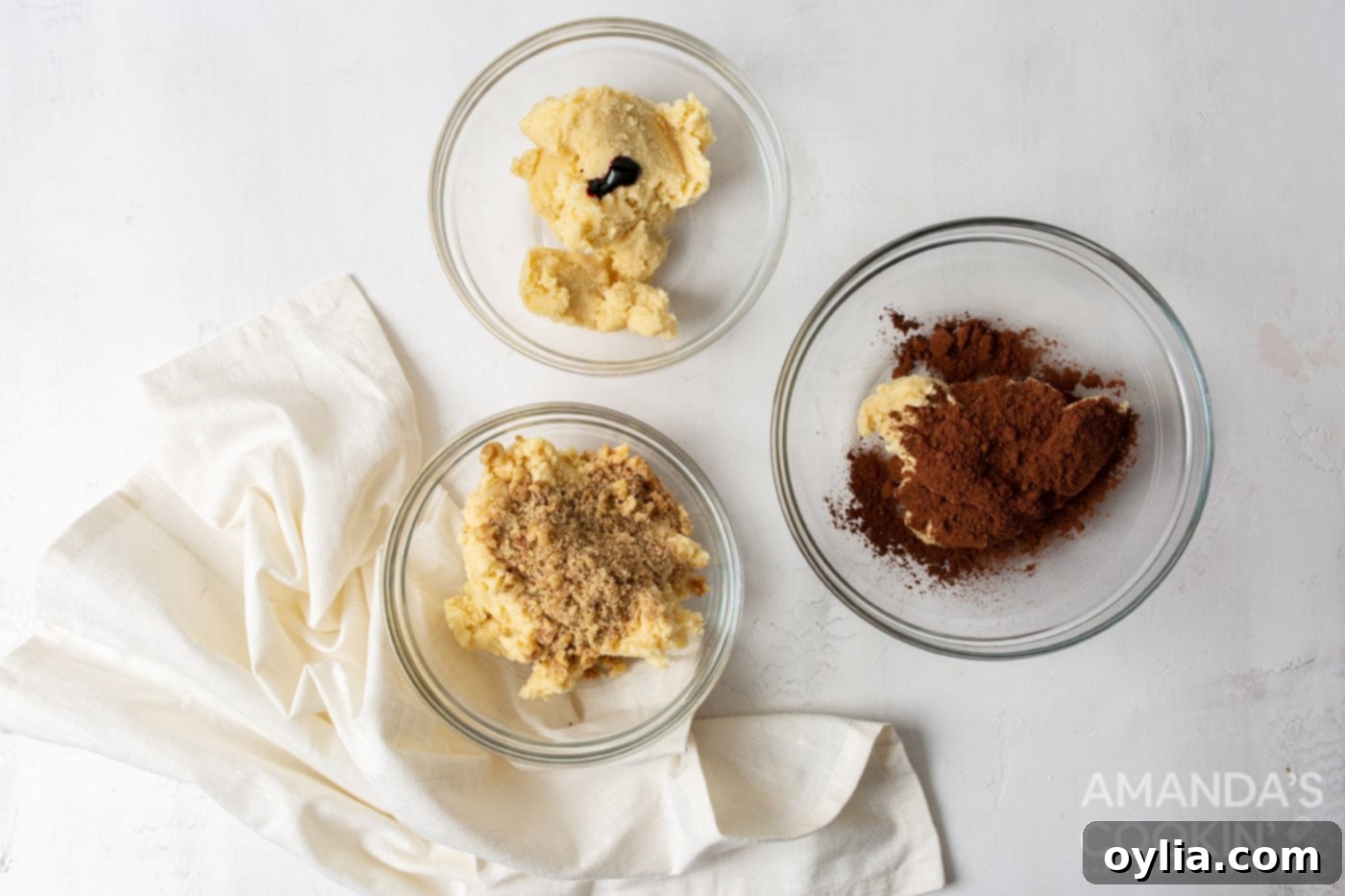 Three bowls of Neapolitan cookie dough, showing the pink, white, and chocolate layers after mixing.