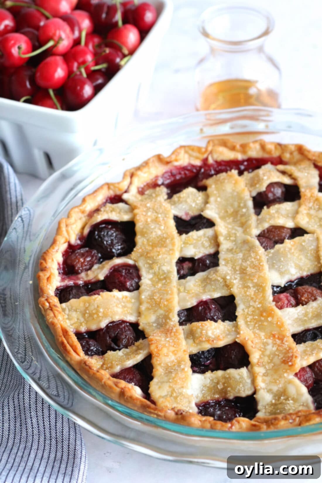 A perfectly baked homemade cherry pie with a golden-brown crust in a pie plate, ready to be served.