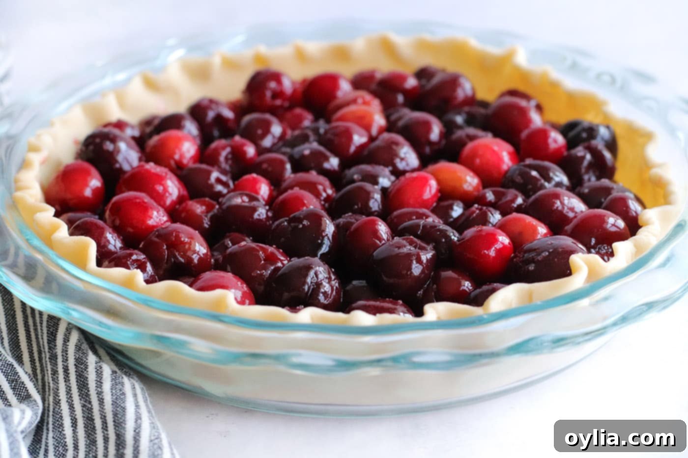 Sweet cherry pie filling generously poured into the bottom pie crust in a baking pan.