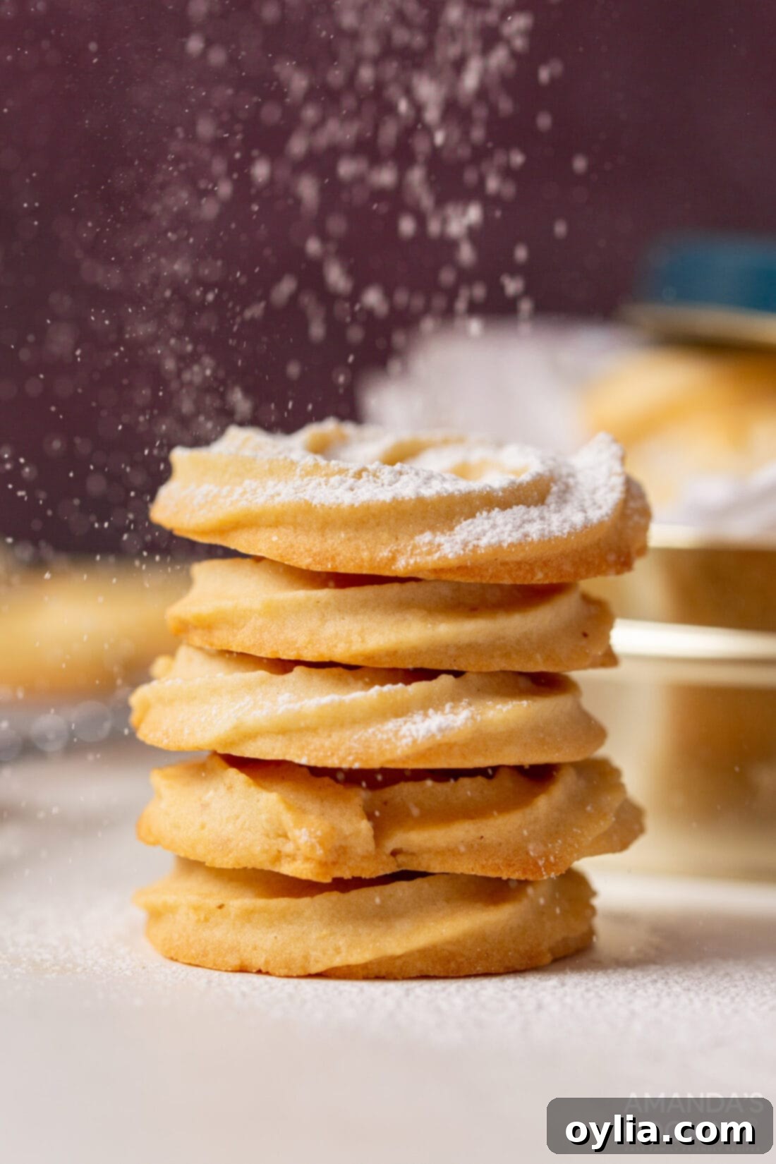 sprinkling powdered sugar on Swedish Butter Cookies