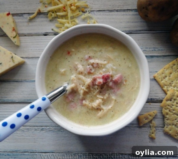 A bowl of Cheesy Chicken & Ham Chowder with a spoon, ready to be enjoyed.