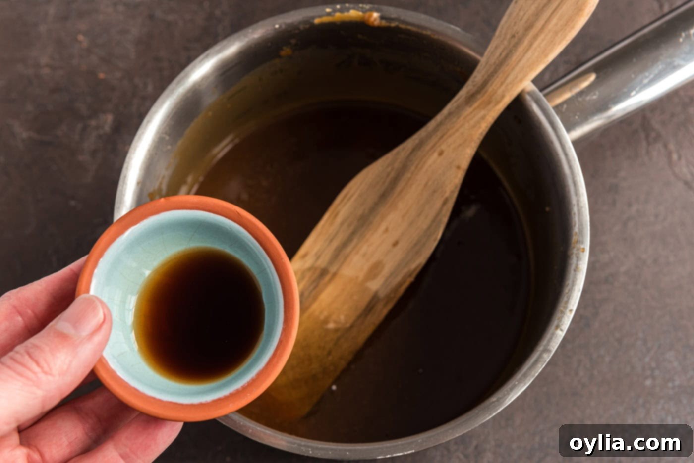 adding vanilla to homemade caramel in a saucepan