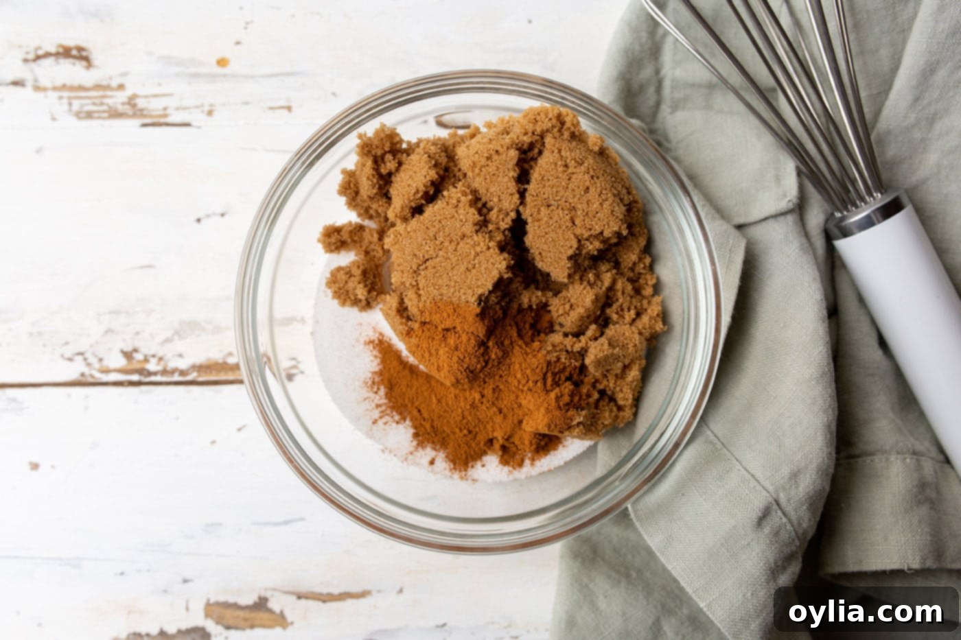 Brown and white sugar with cinnamon and salt in a bowl, whisked together.