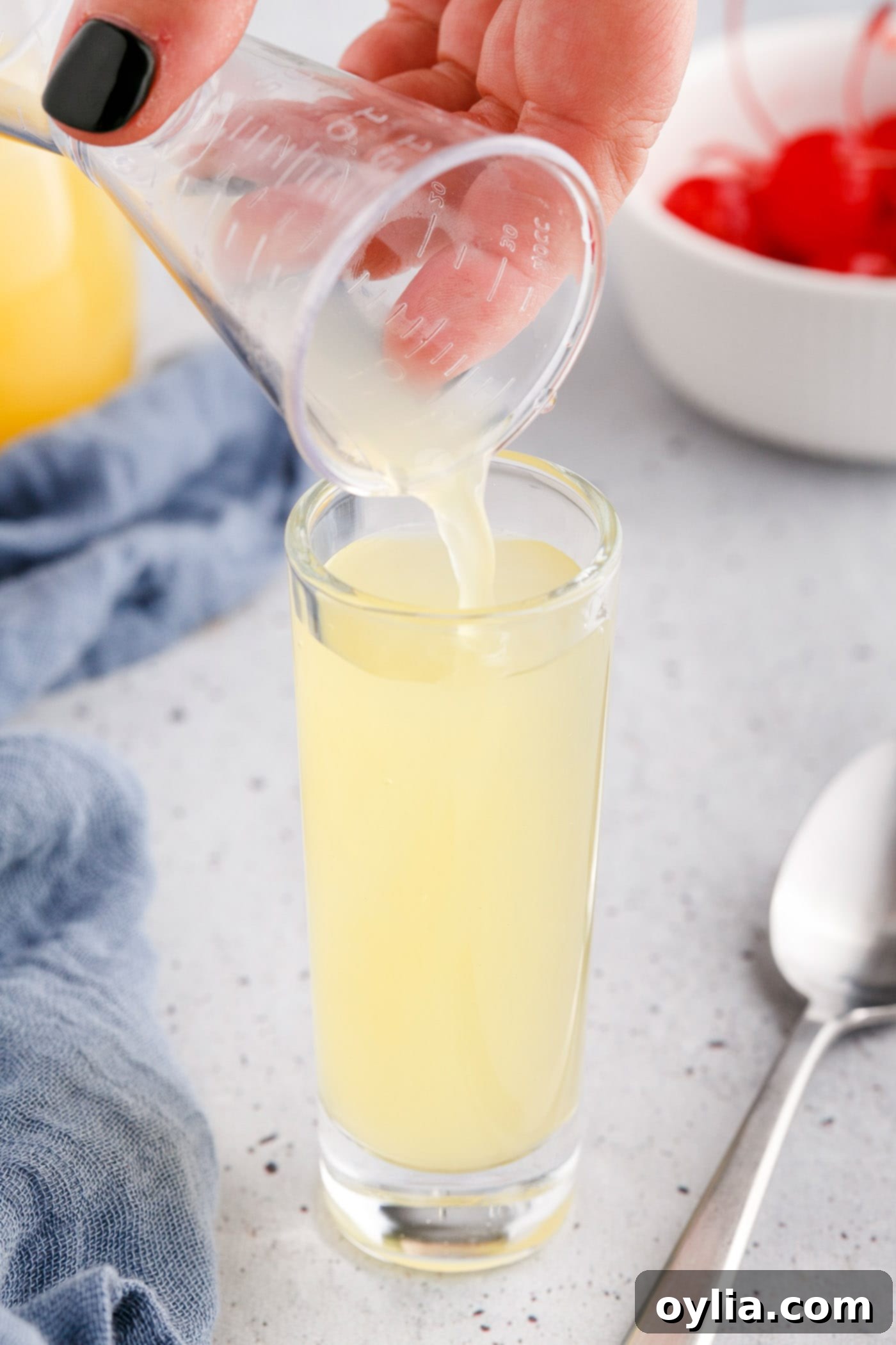 pouring pineapple juice to a shot glass