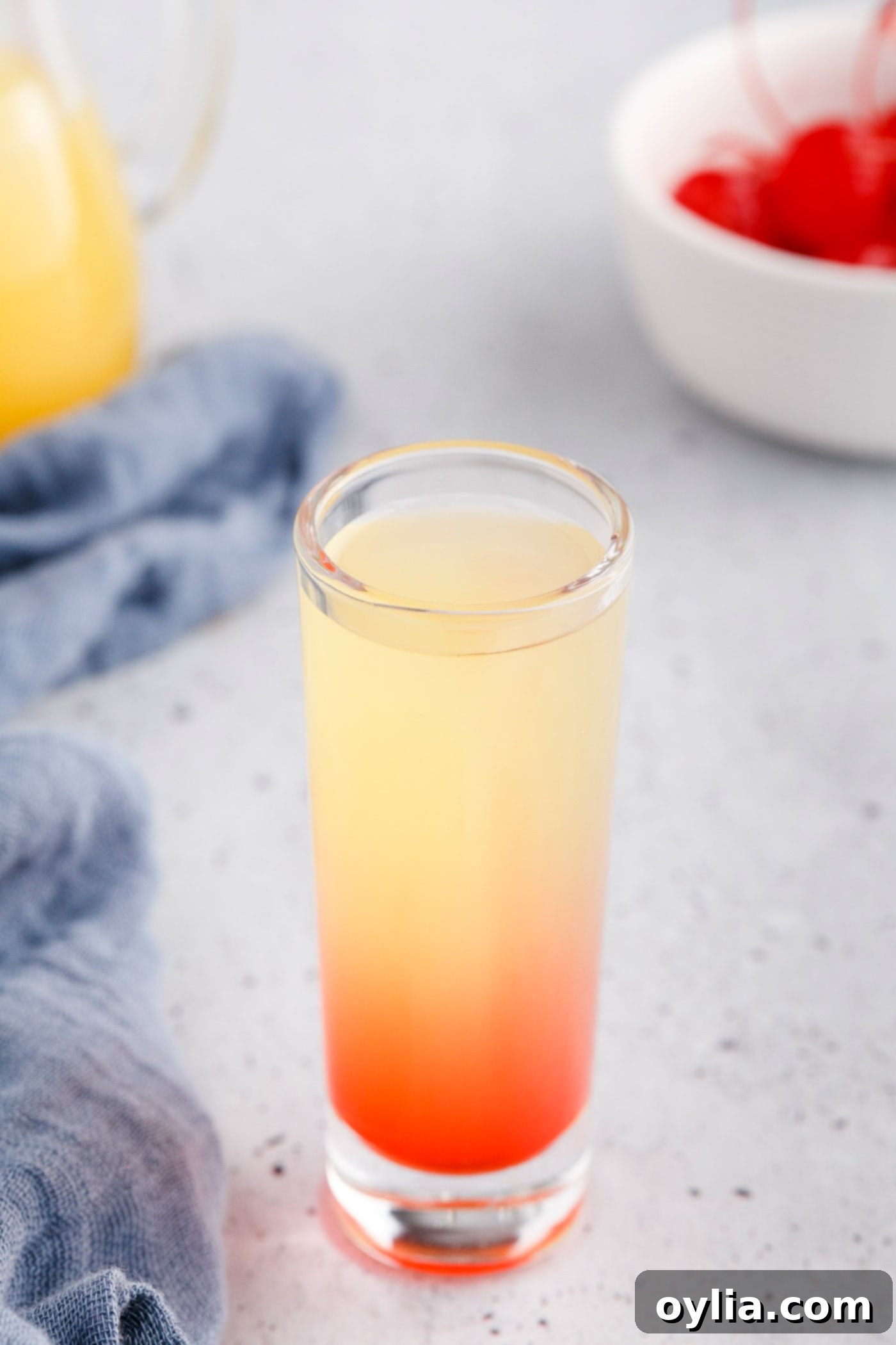 shot glass with grenadine, pineapple juice, and vodka