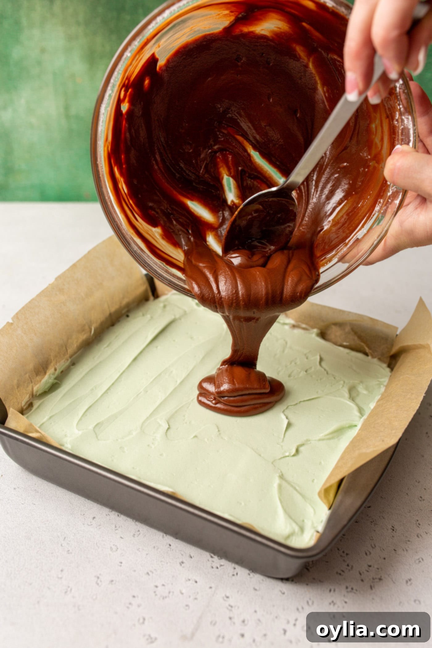 pouring chocolate ganache onto mint chocolate brownies