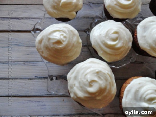 An overhead photo of multiple banana cupcakes, each generously topped with a swirl of vanilla cream cheese frosting, ready to be enjoyed.