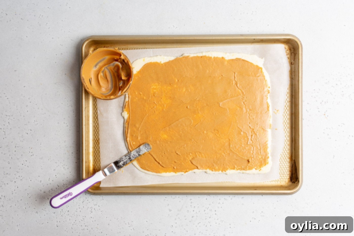 offset spatula smoothing peanut butter on potato dough