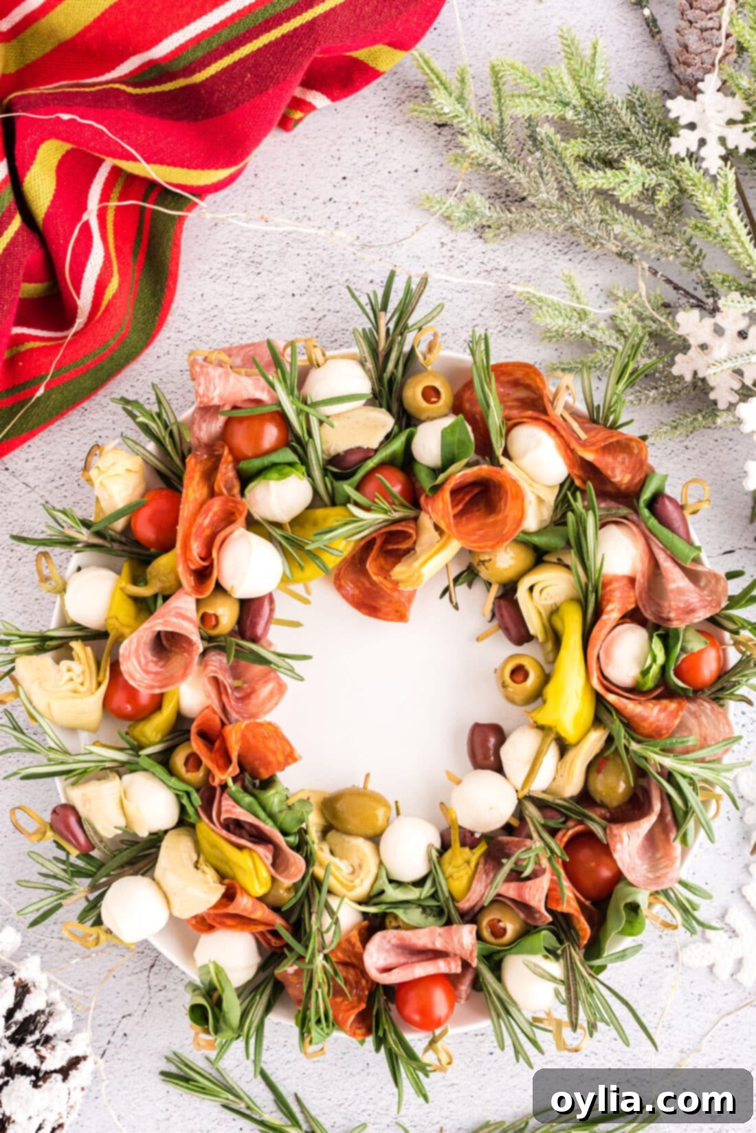 Festive Antipasto Wreath 2 Antipasto Wreath on a plate, adorned with fresh rosemary for a festive look.