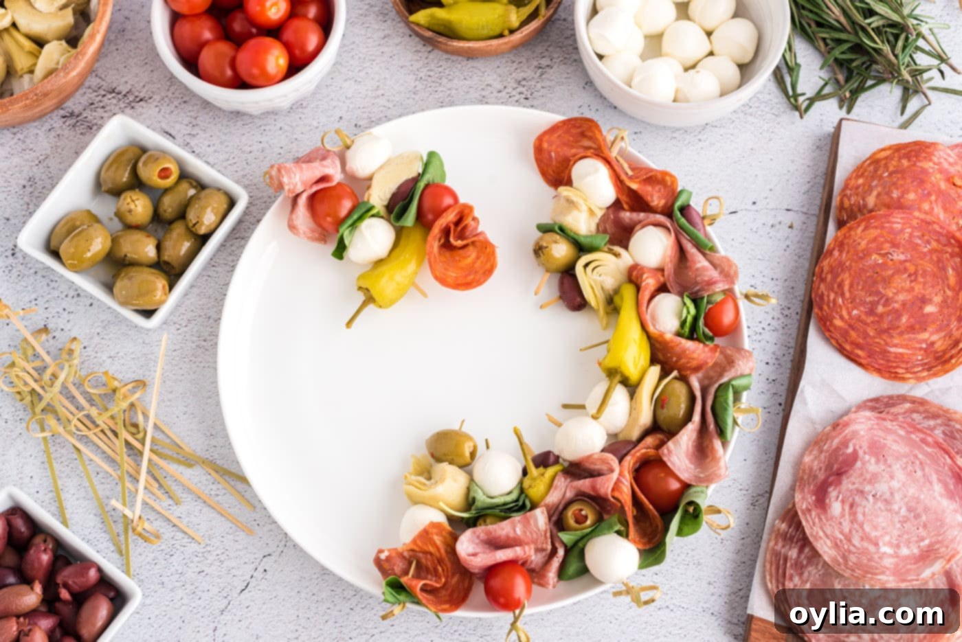 Antipasto skewers artfully arranged in a circular pattern on a plate.
