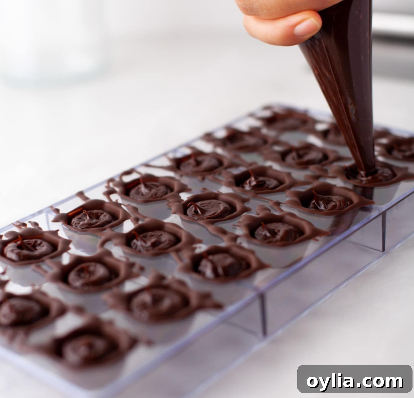 piping ganache into chocolate mold