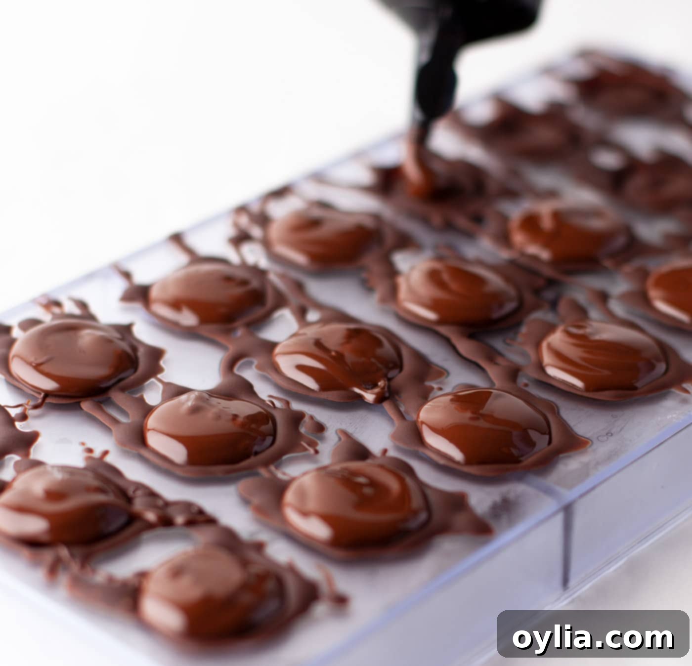 squeezing chocolate over candy mold