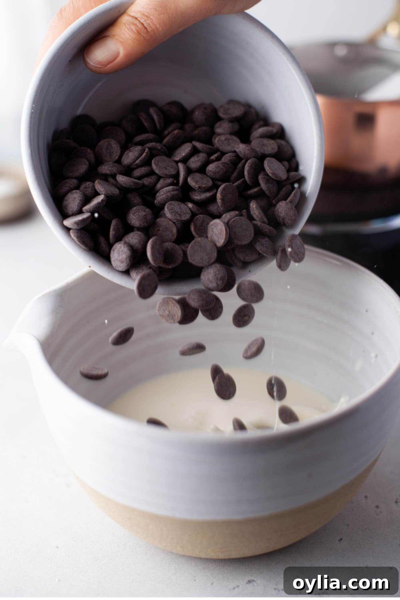 pouring chocolate chips into whipping cream