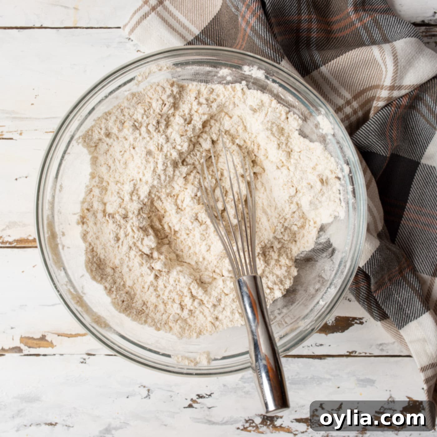 dry ingredients for oatmeal raisin cookies in a mixing bowl being whisked