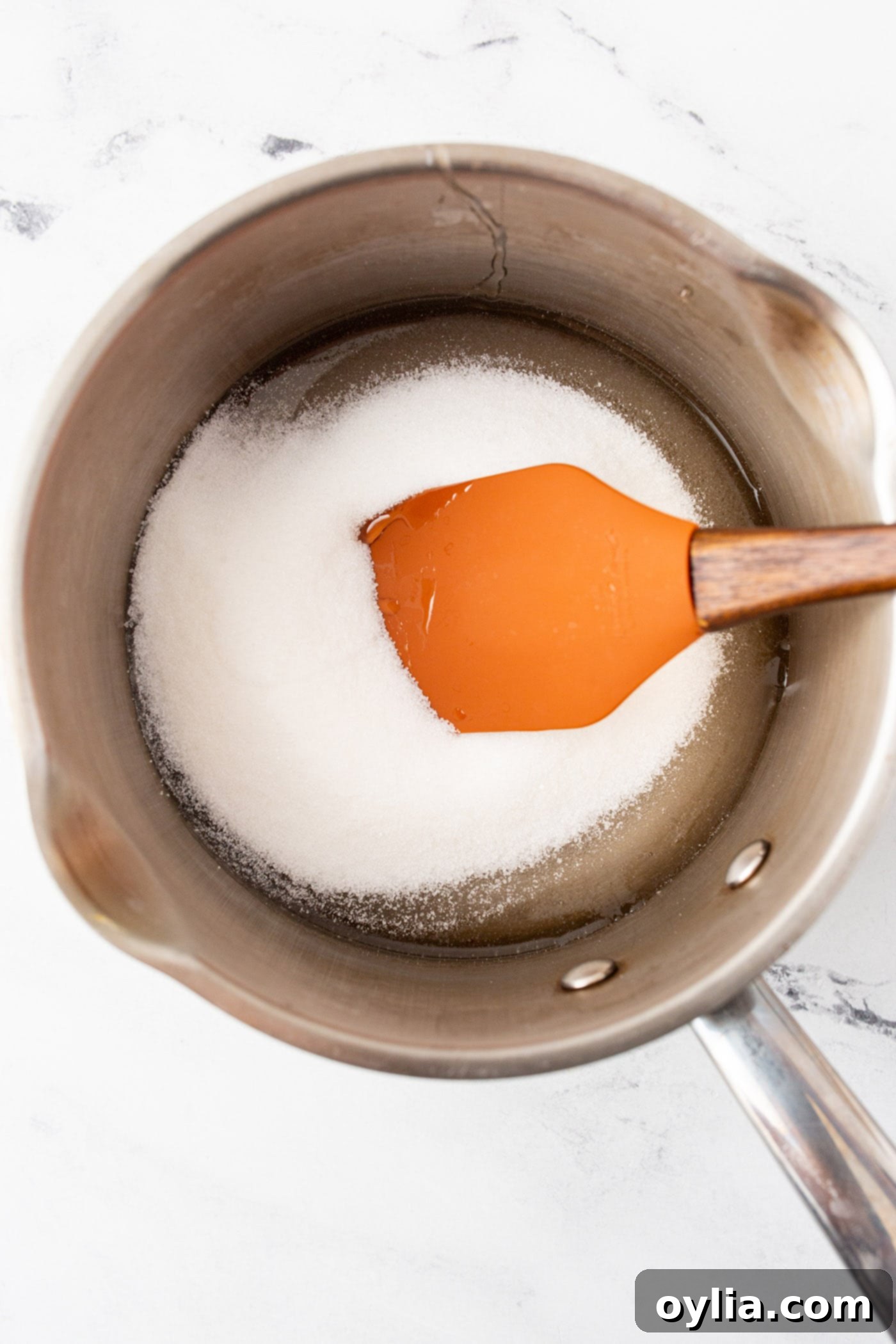 corn syrup and sugar with a rubber spatula in a pot