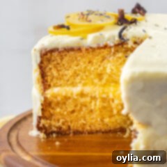 A stunning lemon cake with creamy frosting and fresh lemon slices on top.