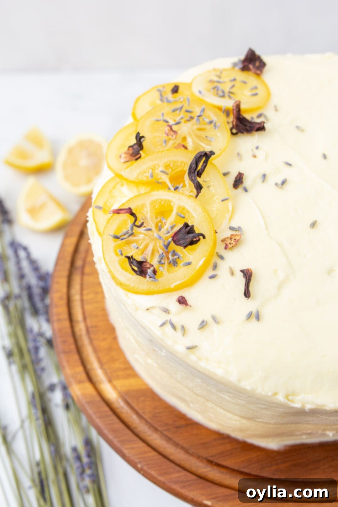 A beautifully decorated lemon layer cake on a white cake stand, ready to be served at a party.