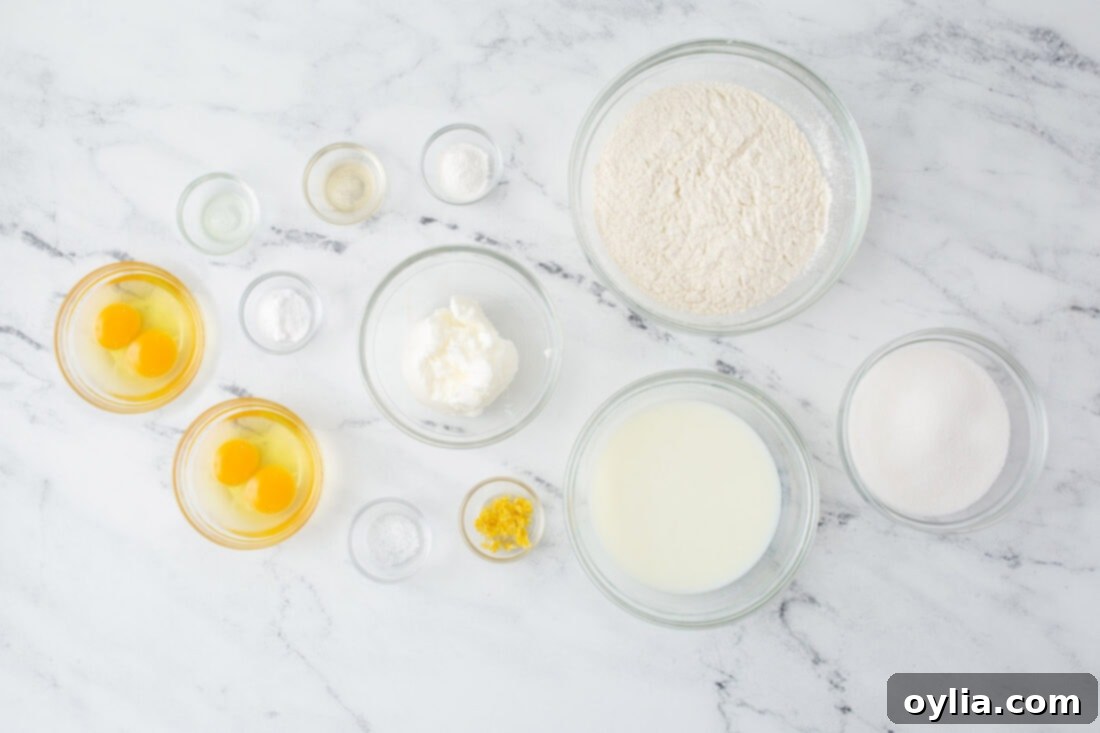 A collection of ingredients laid out for making a lemon cake, including flour, sugar, eggs, and lemons.