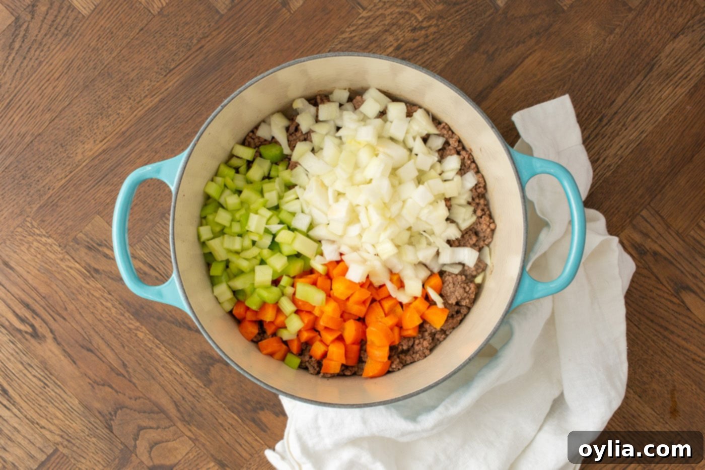 carrots, celery, and onion in a soup pot with ground beef