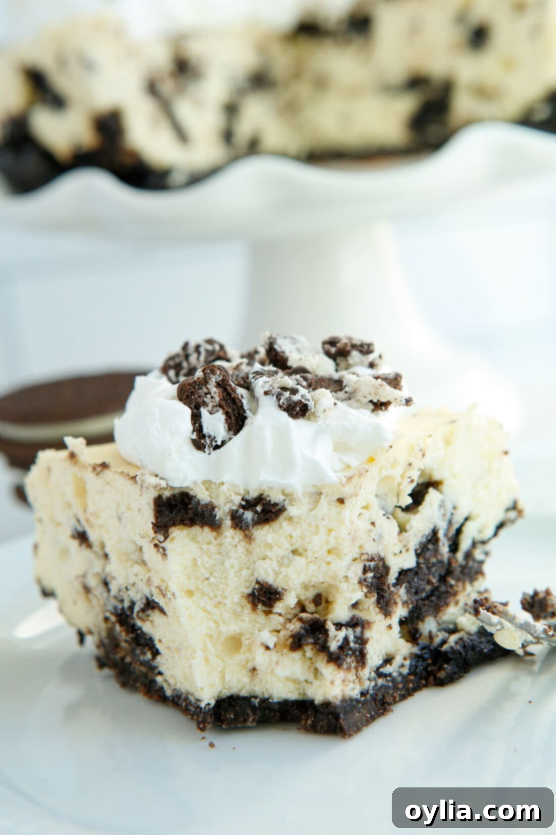 slice of Instant Pot Oreo Cheesecake with a bite taken out, revealing creamy texture and rich cookie crust
