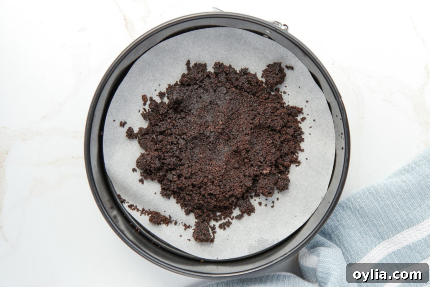 Finely crushed Oreo crumbs ready to be pressed into a springform pan