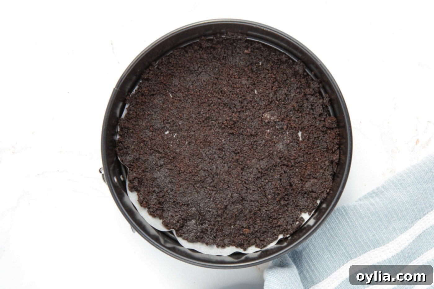 The firm, dark chocolate Oreo cookie crust pressed into a springform pan