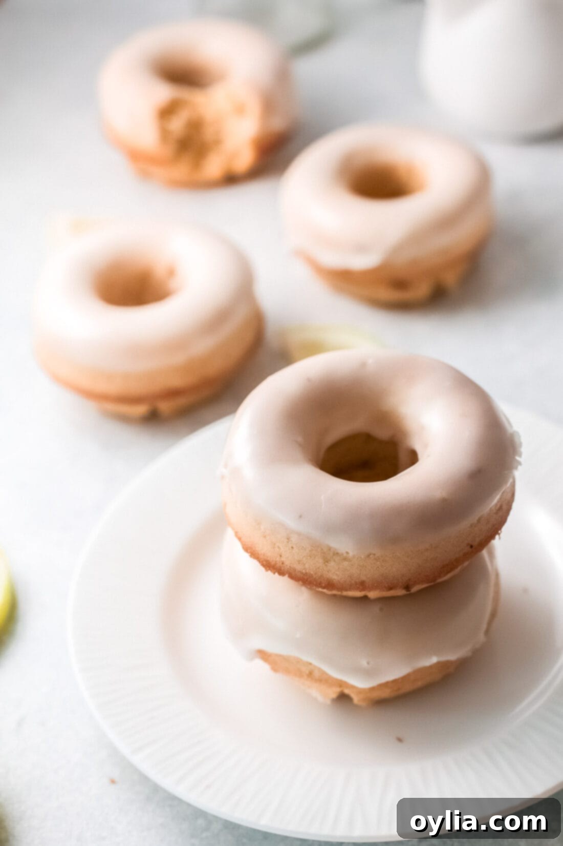 A stack of three lemon baked donuts, perfectly glazed and ready to eat