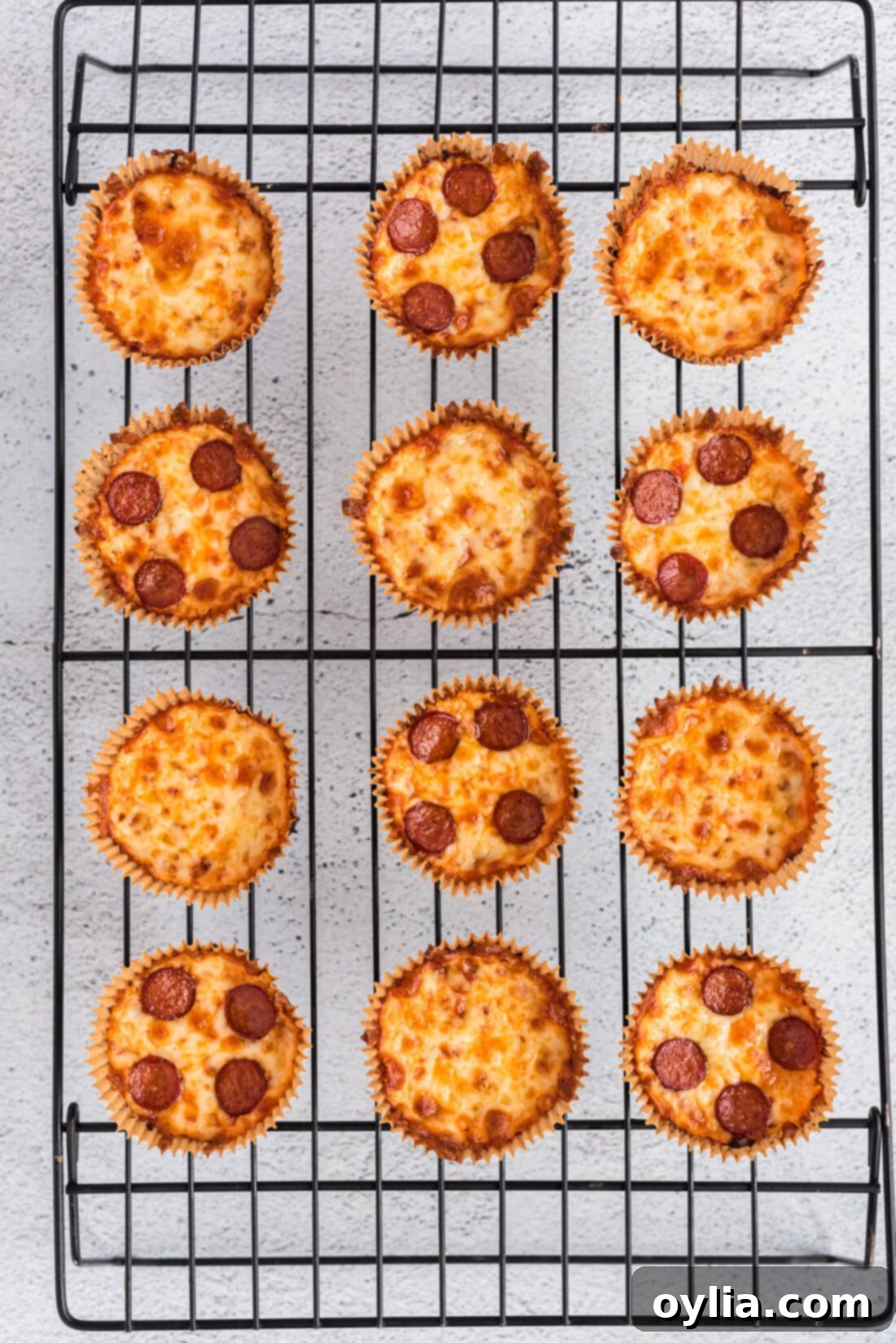 Freshly baked Cauliflower Pizza Bites cooling on a wire rack, showcasing their crispy crust.