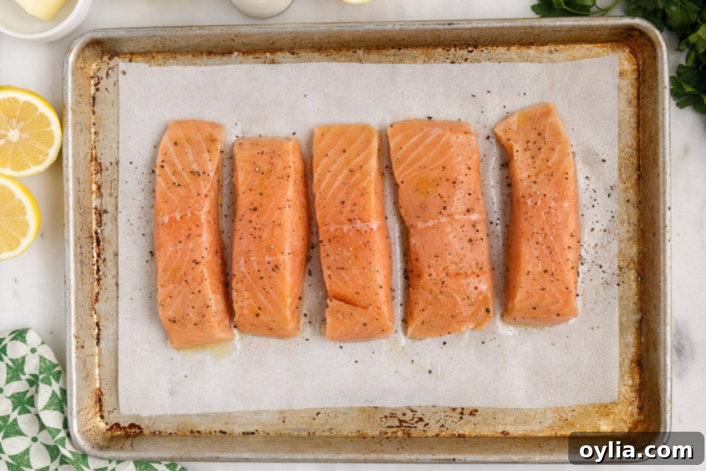 seasoned salmon filets on baking sheet