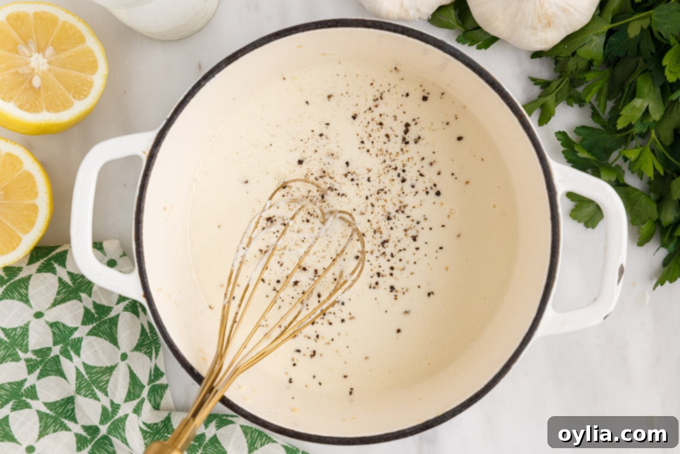 whisking lemon cream sauce in a saucepan
