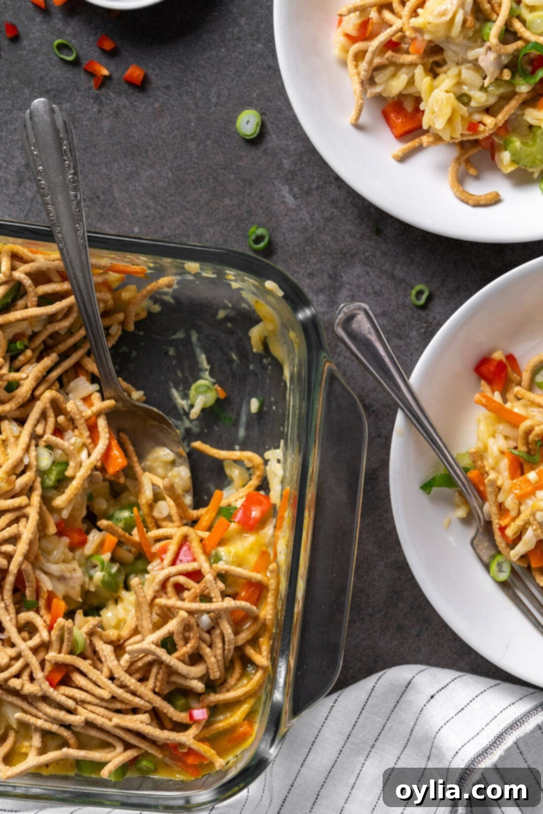 Two plates of Chicken Chow Mein Casserole ready to be served, with the main casserole dish in the background.