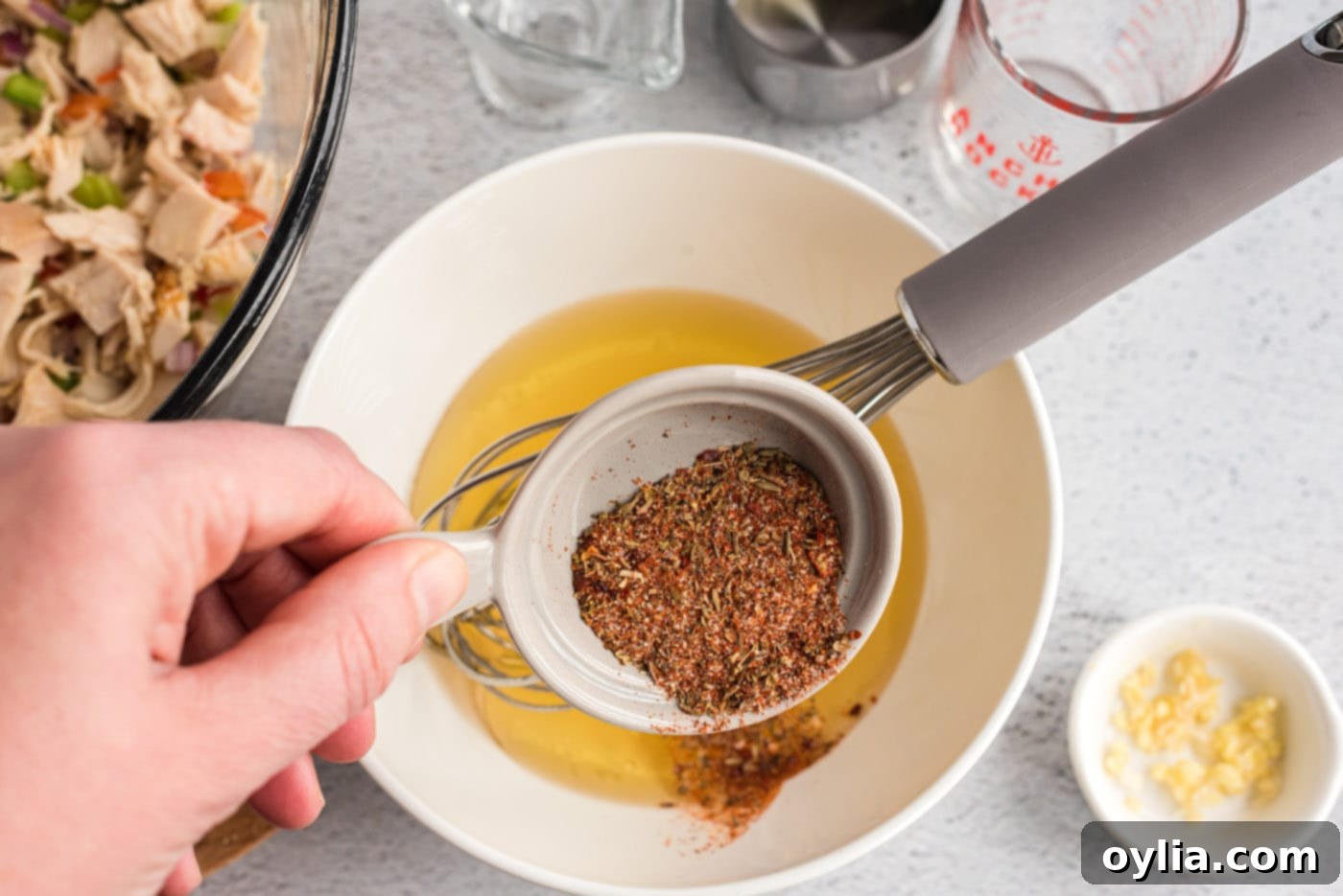 olive oil, garlic, vinegar, broth, and Cajun seasoning in a bowl