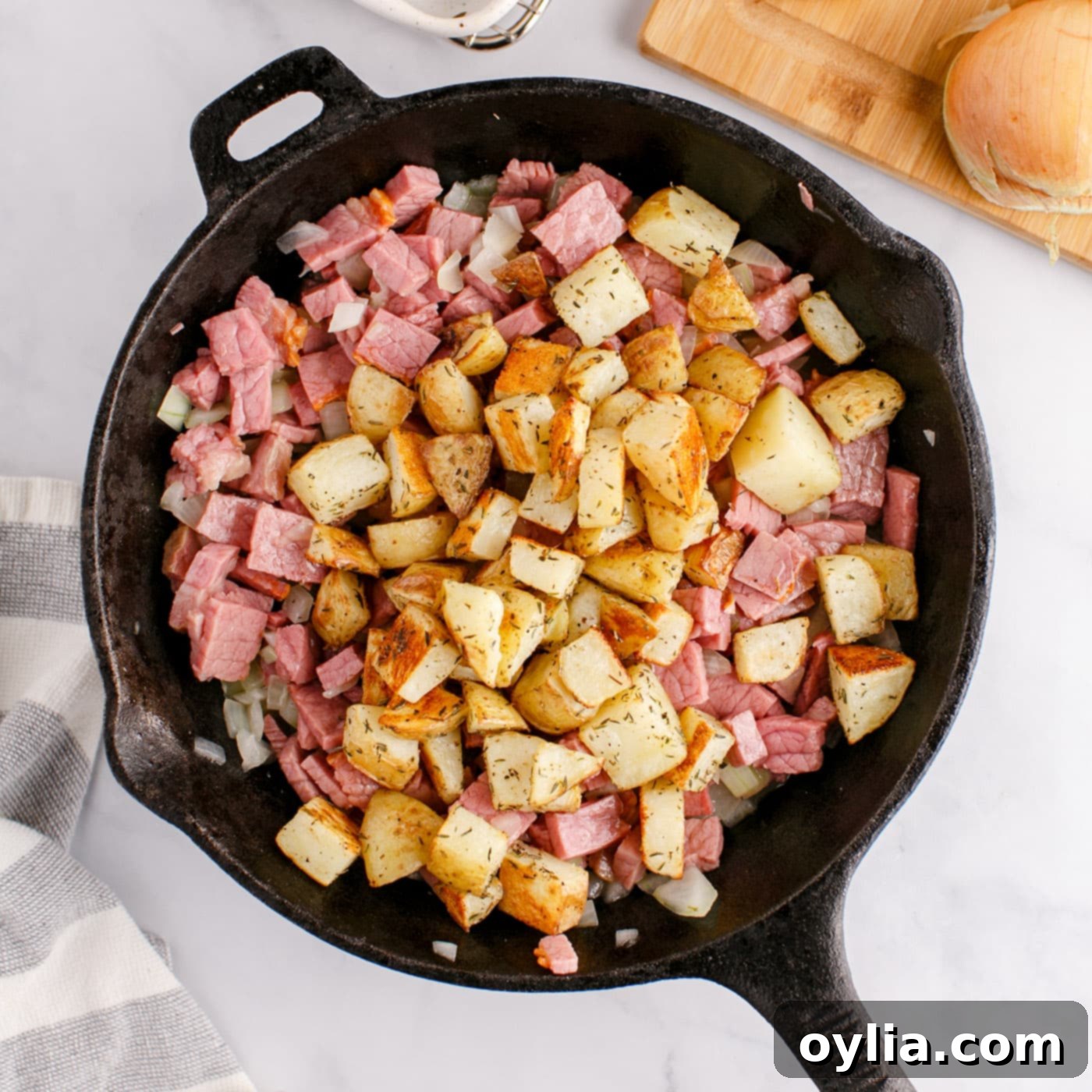cubed potatoes, corned beef, and onions in a skillet