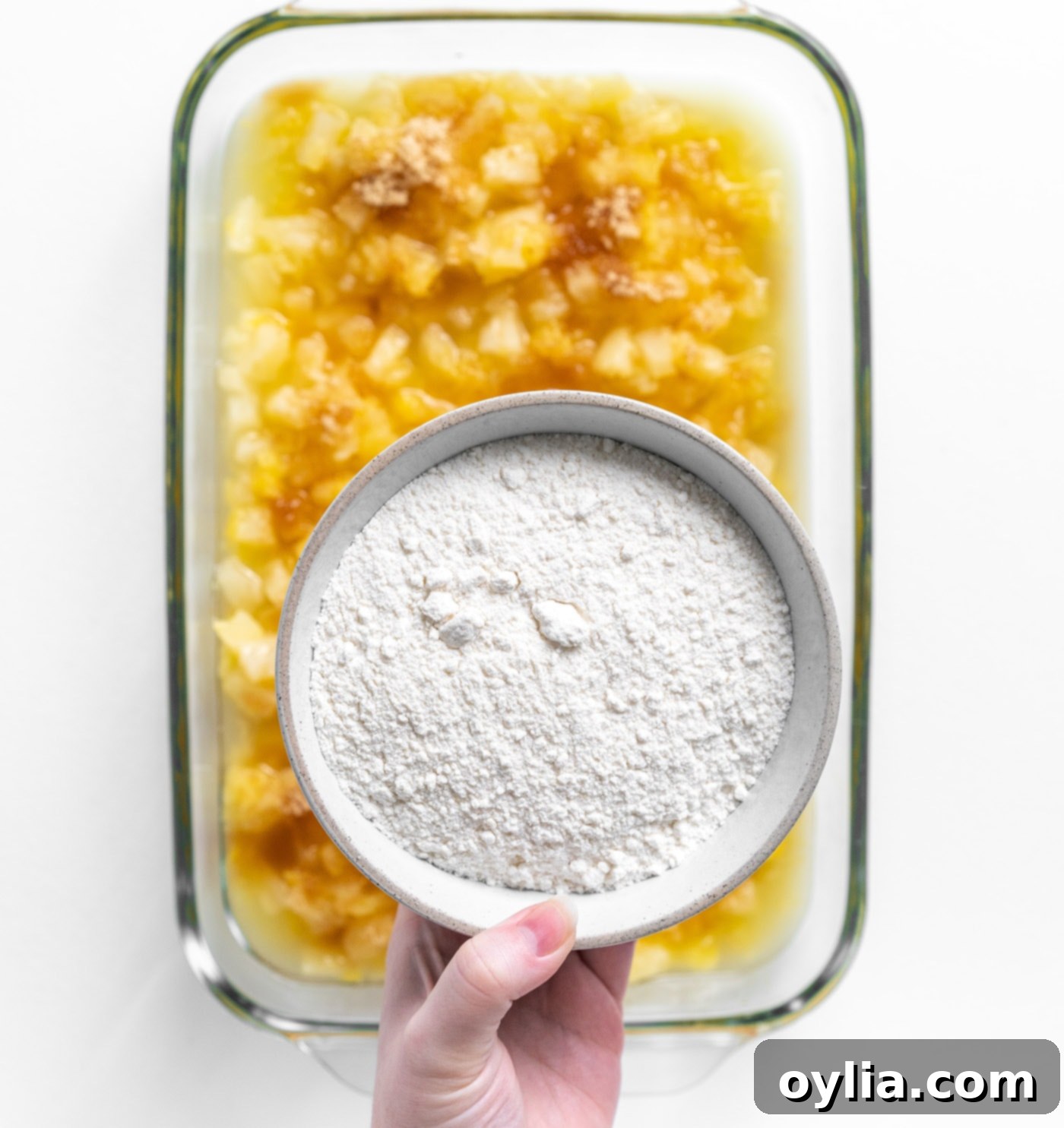 Dry yellow cake mix sprinkled over crushed pineapple and brown sugar in a dish