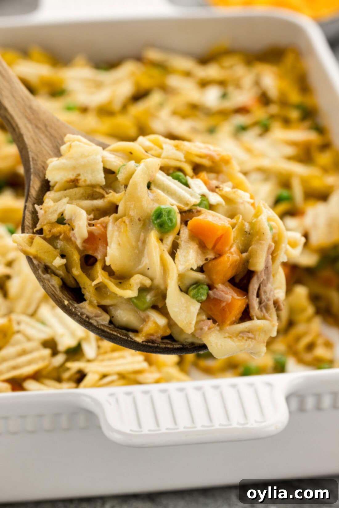 Close-up of a spoonful of Tuna Casserole, showcasing the creamy noodles, tuna, and vegetables